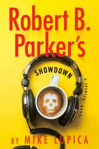 The cover has a yellow background. There is a large pair of over-the-ear headphones. In between the ear cushions is a latte with latte art in the shape of a skull.