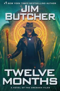 A wizard wears a cowboy hat, silver medallion, and leather trench coat. In his right hand is a fiery staff and behind him a magical glyph.