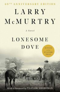 The cover has two cowboys herding cattle. The photo is in black and white.
