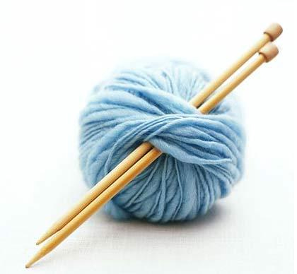 two knitting needles in a light blue ball of wool