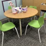 image of table with craft and maker supplies surrounded by green chairs