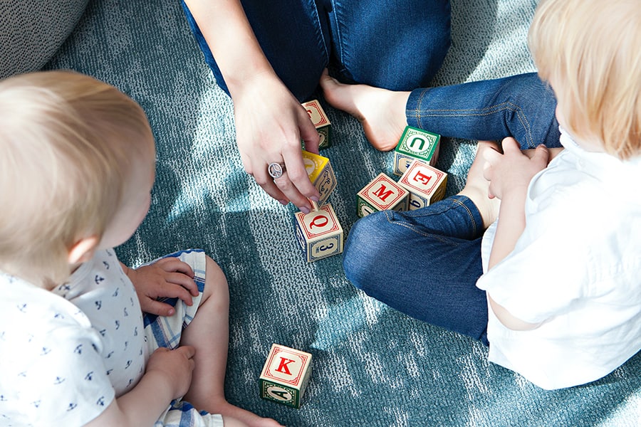 image of adult and two young children playing with blocks