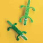 image of two green crocodiles made out of popsicle sticks and pipe cleaners.