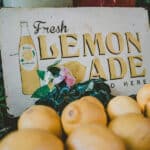 photo of lemons in front of a 'fresh lemonade' sign