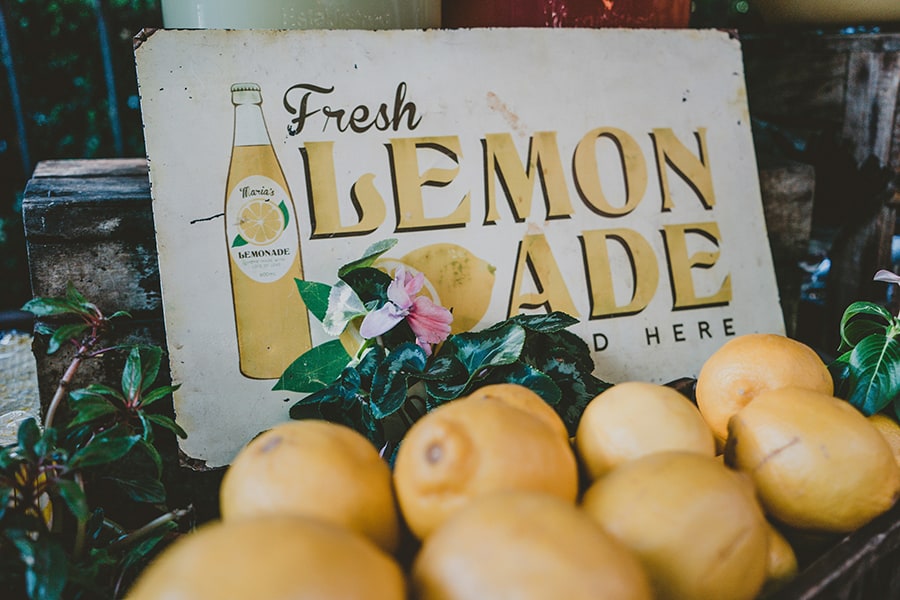 photo of lemons in front of a 'fresh lemonade' sign