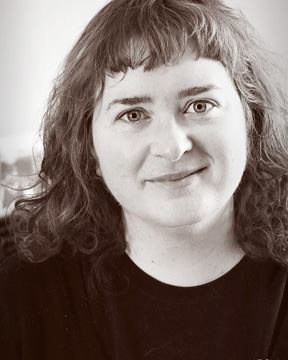 sepia head and shoulders photo of woman with shoulder length hair wearing a black top