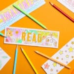 table with four colouring bookmarks and eight coloured pencils.