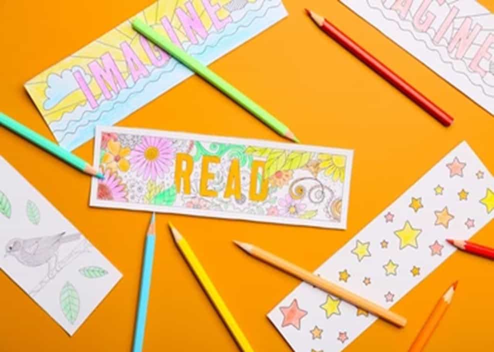 table with four colouring bookmarks and eight coloured pencils.