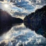 photograph of a calm lake reflecting the sky.