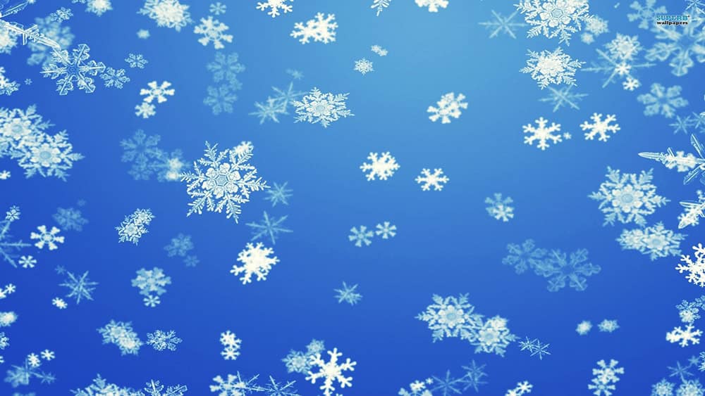 snowflakes falling against a blue sky