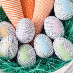 image of paper-covered Easter eggs and knitted carrots in a basket