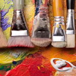 image of a row of paint brushes of various sizes on a painted canvas.