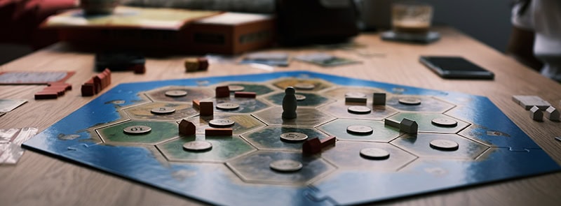 image of the board game Catan with pieces on an octagon-shaped board