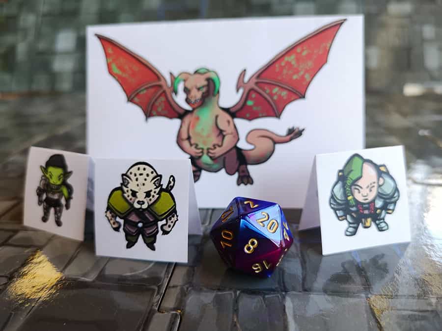 image of three cardboard pieces with creatures on them and a two multi-sided die