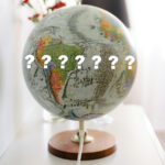 image of a globe with white question marks on it.