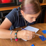 image of a girl using an eyedropper to drop liquid onto a blue slide.