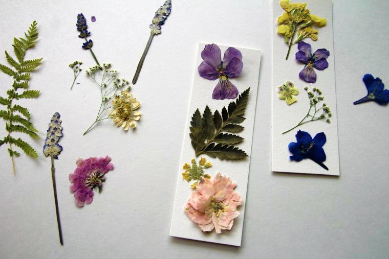 image of pressed flowers on a table and on two bookmarks