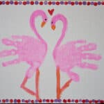 image of two pink flamingos made from hand prints.