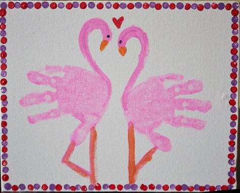 image of two pink flamingos made from hand prints.