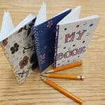 image of three small booklets on a table with three pencils