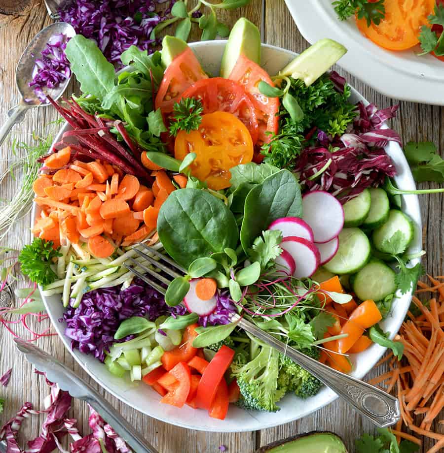 image of a salad in a bowl with a fork on a table