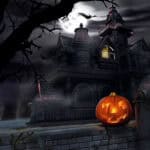 image of a haunted house with an orange jack-o-lantern in front.