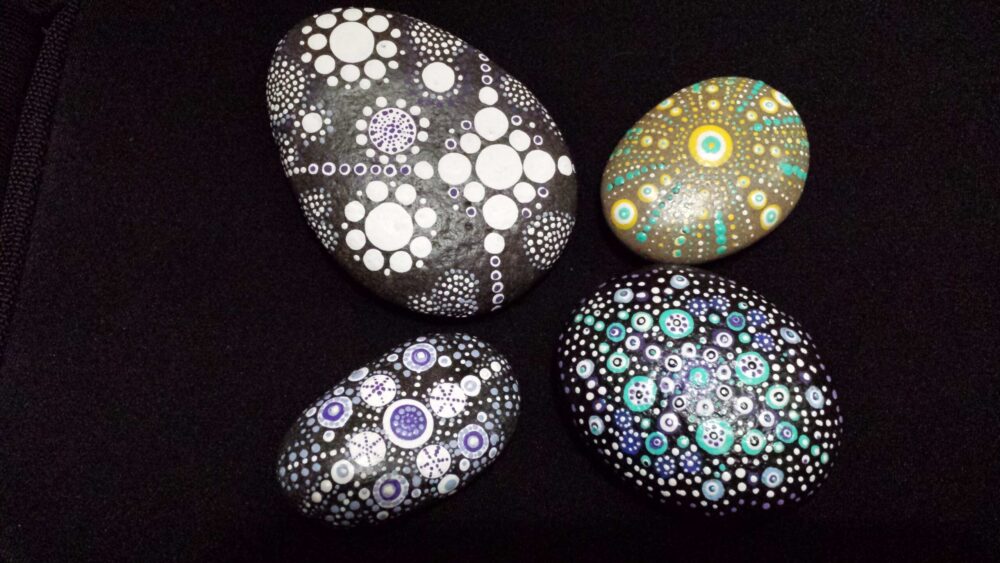 image of four rocks painted with mandalas