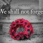 image of a red poppy wreath at the base of a cenotaph.