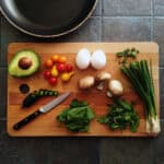 image of cut vegetables and two eggs on a cutting board.