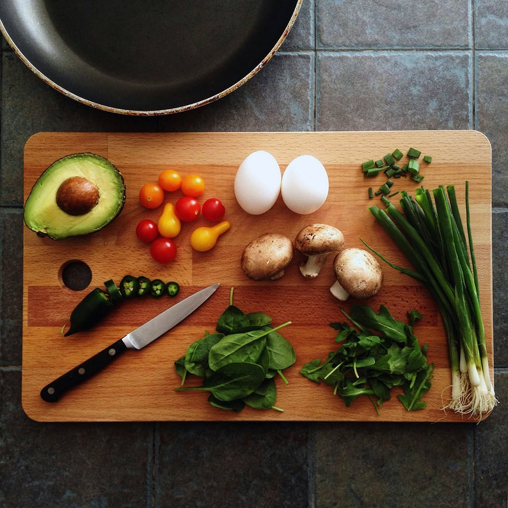 image of cut vegetables and two eggs on a cutting board.