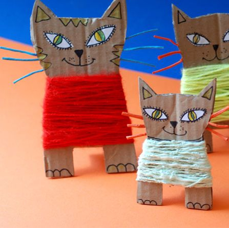 image of three cardboard cats with coloured yarn wrapped around them.