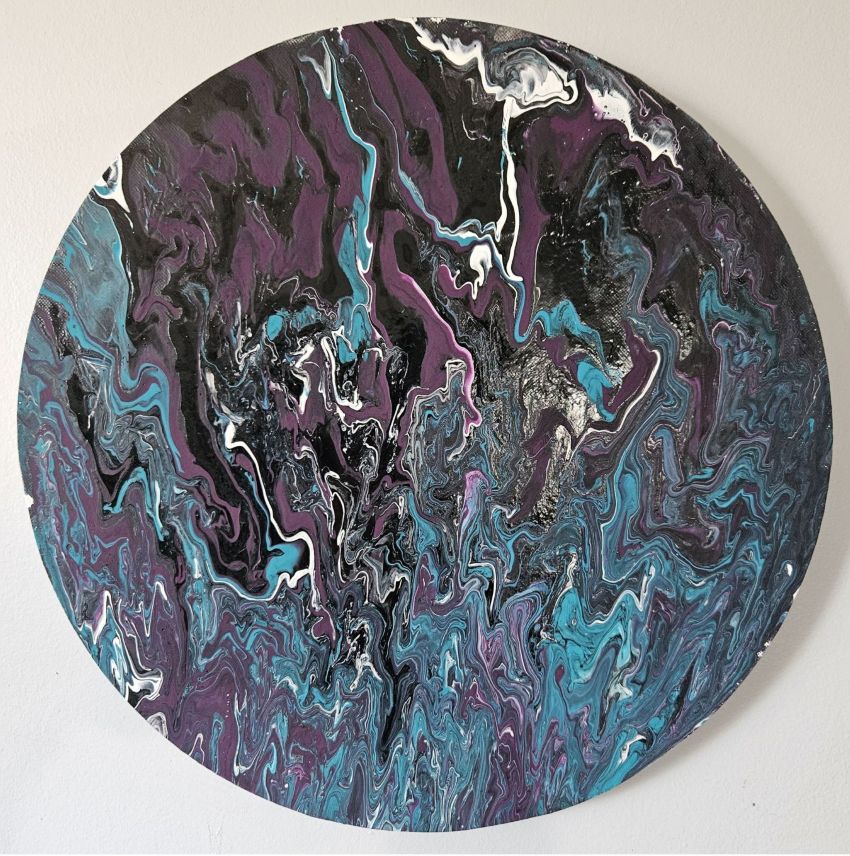 A round painting of paint splatters in blue, purple, black, and white.