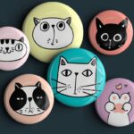 6 Button pins with funny looking cats on them.