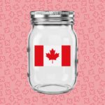 An empty mason jar with the Canadian flag on it. The background is red with lots of tiny maple leaves.