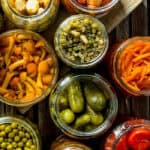 Jars of vegetables preserved in liquid. The lids are off so you can see what is inside.