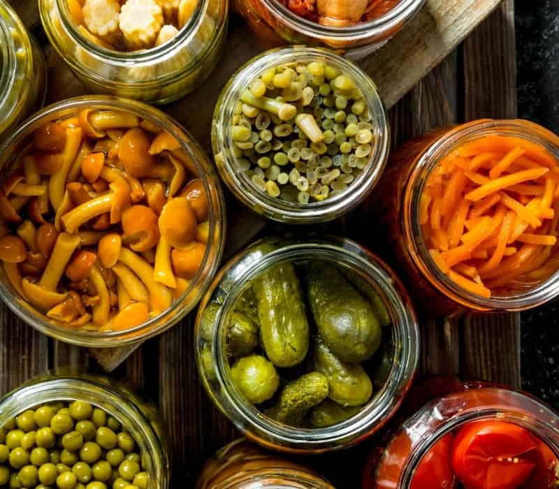 Jars of vegetables preserved in liquid. The lids are off so you can see what is inside.
