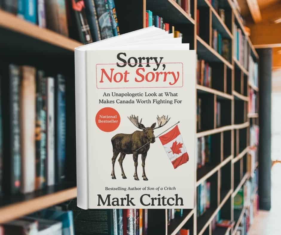 The cover of Sorry, Not Sorry. It features a moose holding a Canadian flag in its mouth. Behind the cover are shelves of books.
