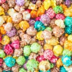 Lots of popcorn with rainbow coloured candy coating on it.