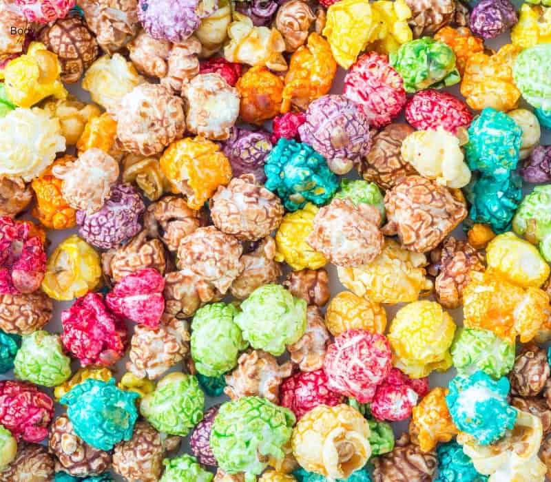 Lots of popcorn with rainbow coloured candy coating on it.