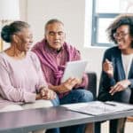 An aging African-Canadian couple looking at legal documents for their wills.