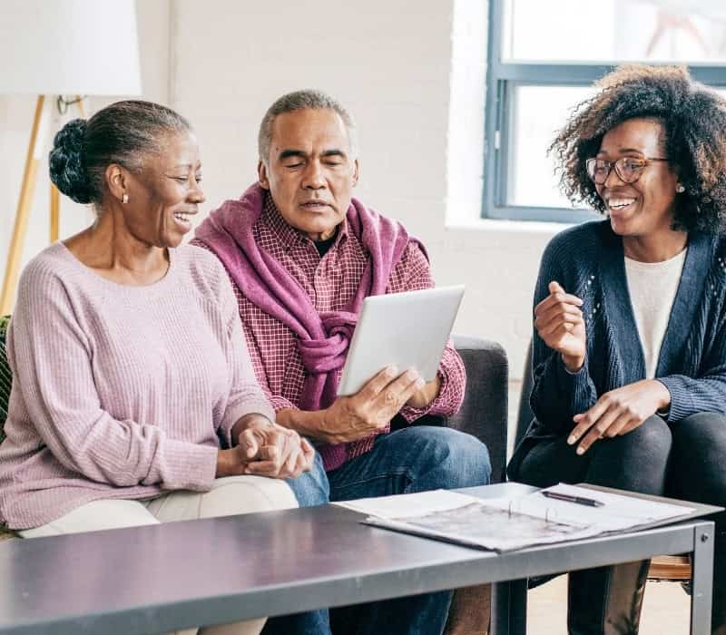 An aging African-Canadian couple looking at legal documents for their wills.
